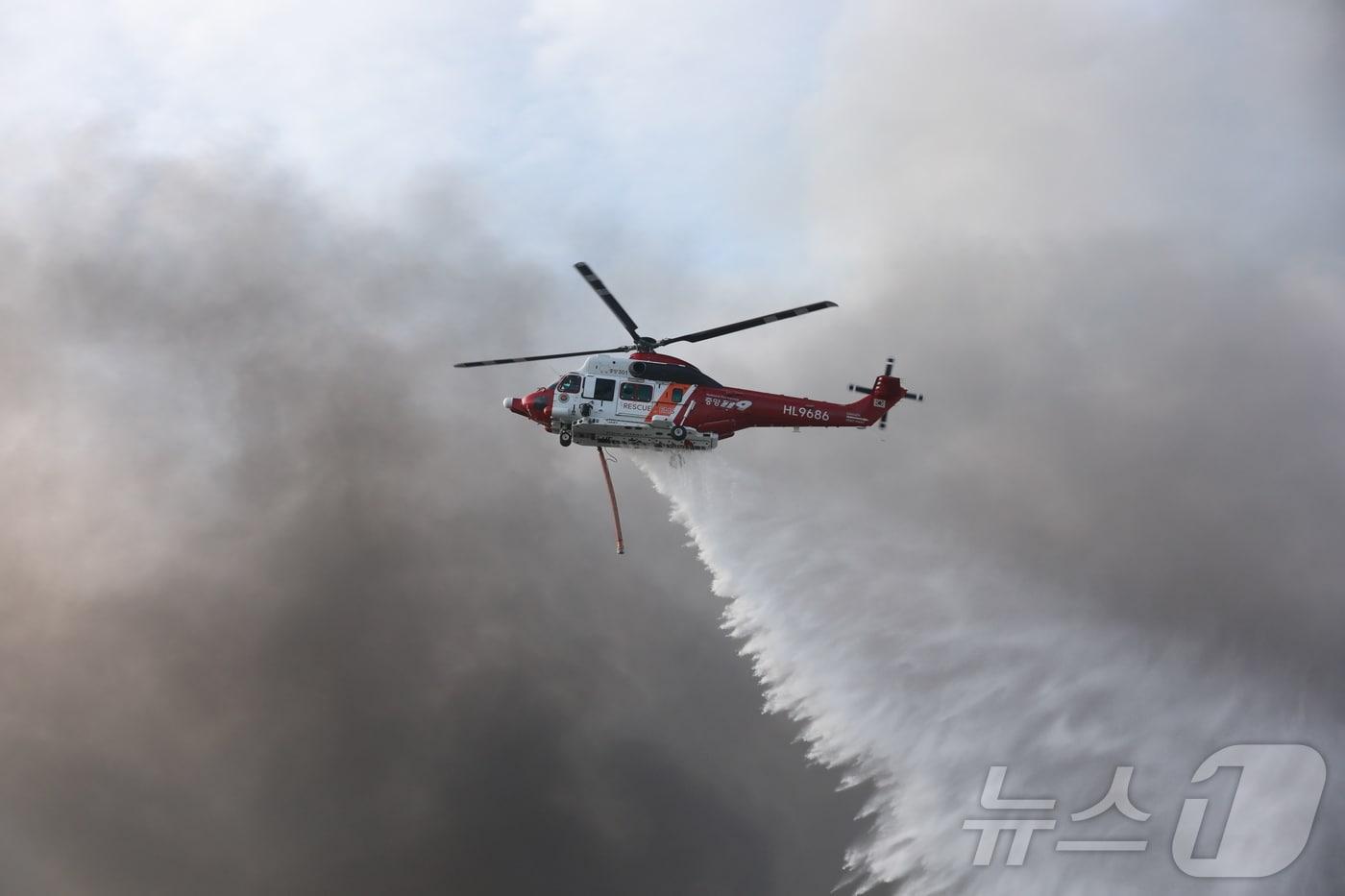 본문 이미지 - 금호타이어 광주공장 화재 발생 이틀쨰인 18일 오전 소방 헬기가 검은 연기를 뚫고 화재 현장에 물을 뿌리고 있다. 2025.5.18 ⓒ 뉴스1 최성국 기자