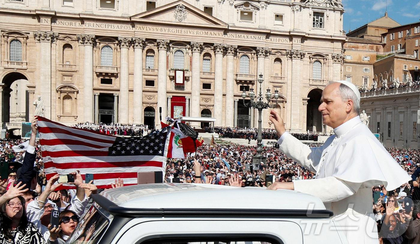 본문 이미지 - 교황 레오 14세가 바티칸 성 베드로 광장에서 열린 즉위 미사에 앞서 포프모빌(교황 전용차량)에서 신자들에게 손을 흔드는 동안 미국 성조기가 들어 올려져 있다. 2025.5.18ⓒ 로이터=뉴스1 ⓒ News1 신기림 기자