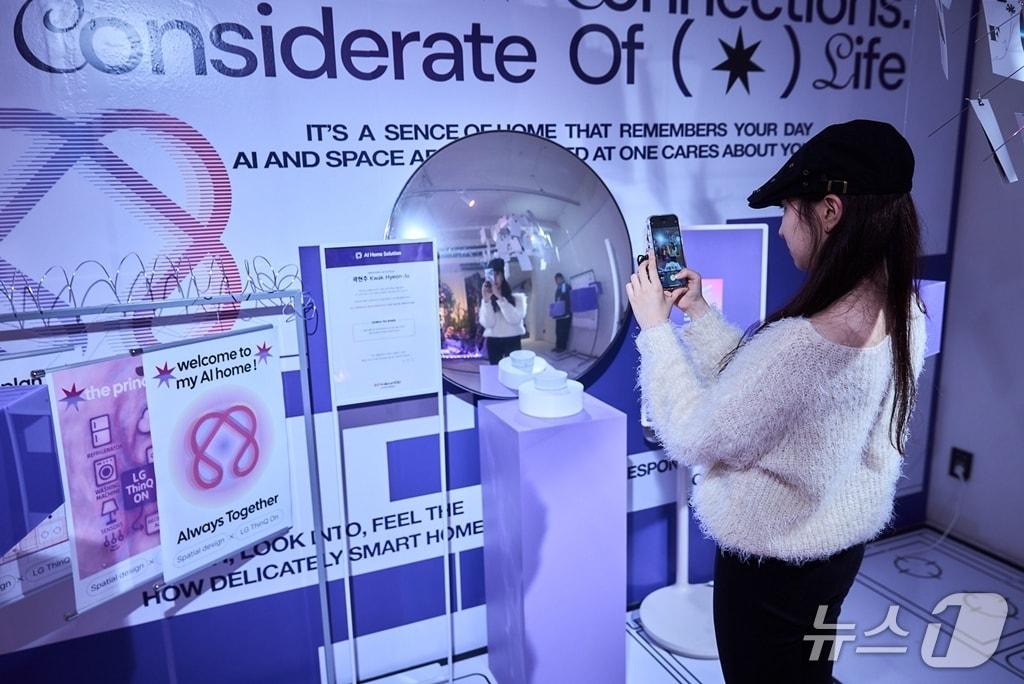 본문 이미지 - 16일 서울 성수동에서 열린 'LG 공감지능 AI 팝업갤러리' 방문객이 SNS 이벤트 참여를 위해 AI홈 허브 인증 사진을 촬영하고 있다(LG전자 제공). ⓒ 뉴스1