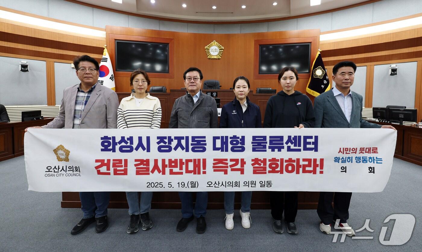 오산시의회 의원들이 동탄2 물류센터 건립 철회를 촉구하는 현수막을 들고 있다.(오산시의회 제공) 