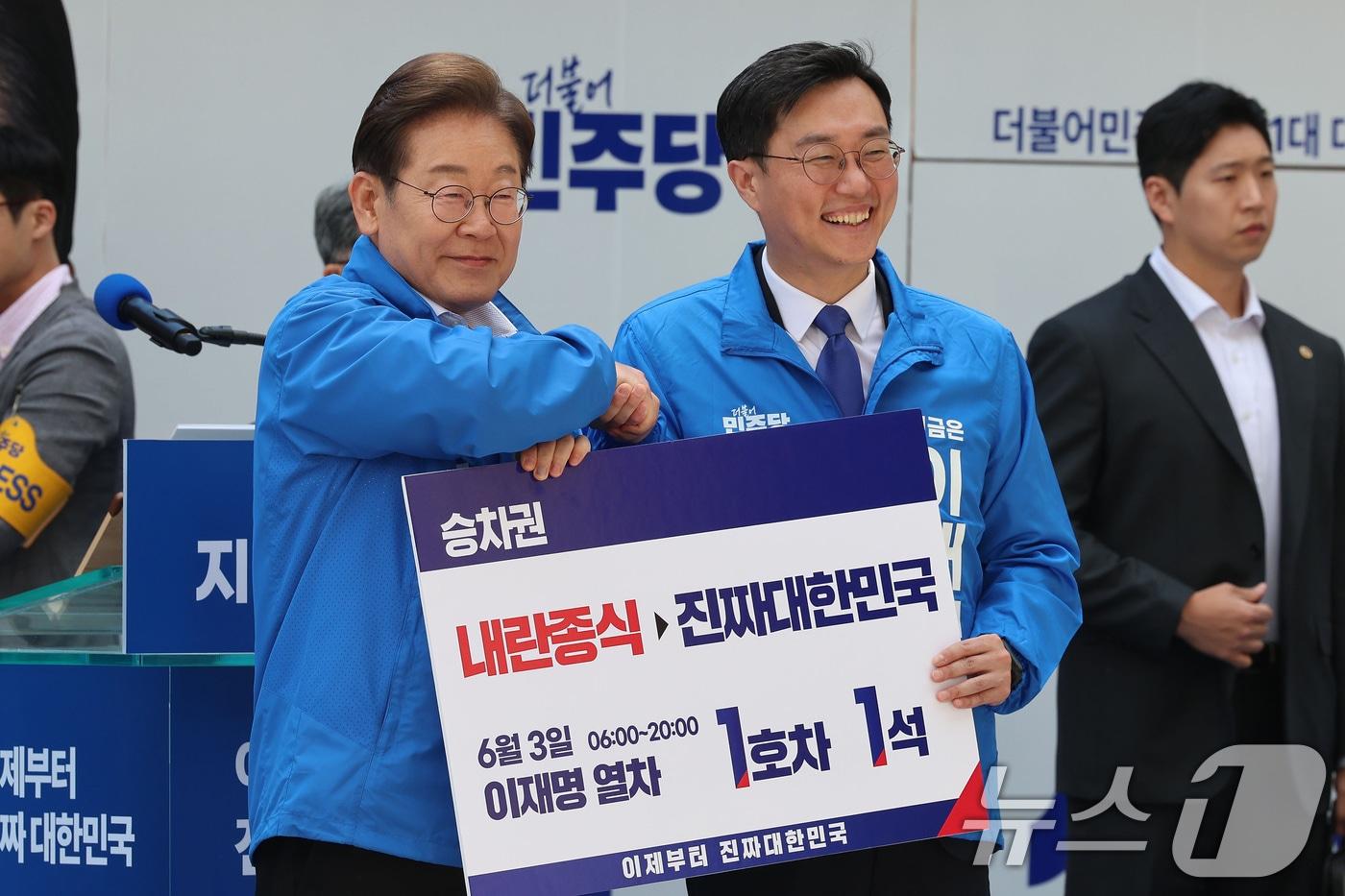 이재명 더불어민주당 대통령 후보가 19일 서울 용산구 용산역 광장에서 열린 집중유세에서 장경태 의원으로부터 이재명 열차 승차권을 받은 뒤 기념촬영을 하고 있다. (공동취재) 2025.5.19/뉴스1 ⓒ News1 안은나 기자