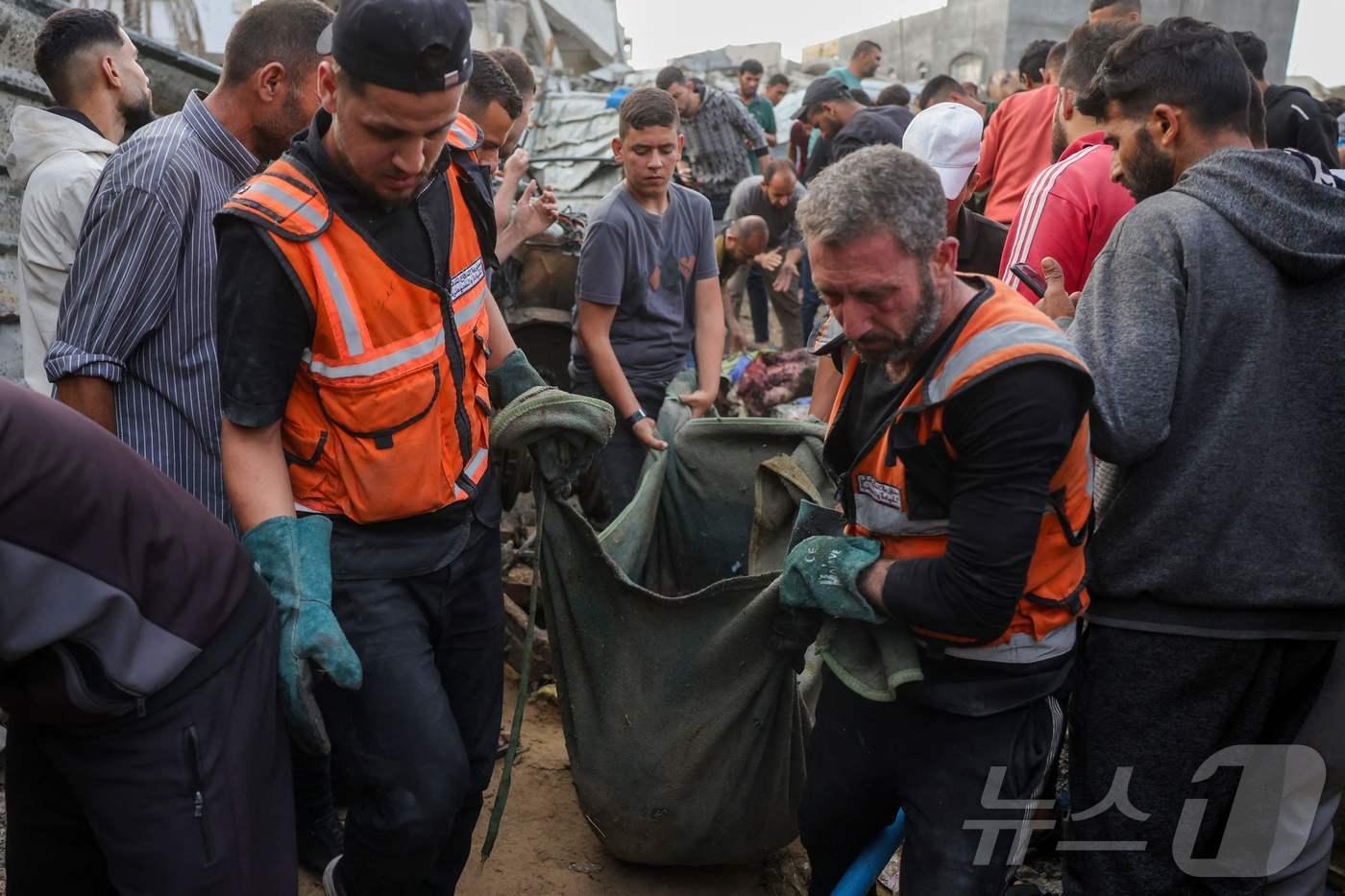 팔레스타인 구조대가 18일(현지시간) 가자지구 북부 자발리아의 알 사프타위 지역에서 이스라엘 공습으로 숨진 이의 시신을 수습하고 있다. 2025.05.18. ⓒ AFP=뉴스1 ⓒ News1 이지예 객원기자
