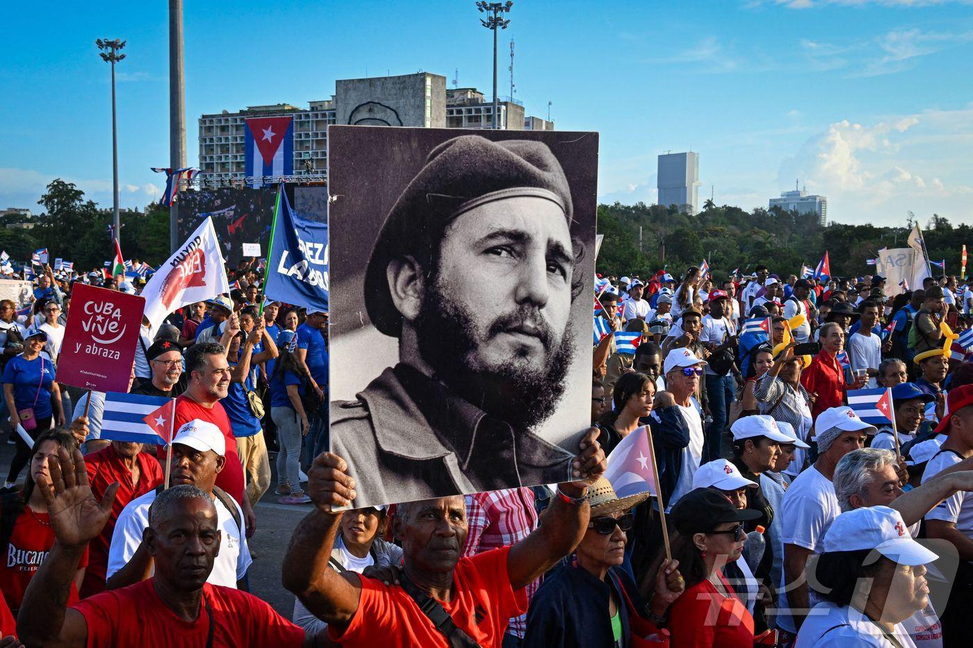 1일&#40;현지시간&#41; 쿠바 아바나 혁명광장에서 열린 노동절 집회에서 한 사람이 쿠바 혁명 지도자인 피델 카스트로의 사진을 들고 있다. 2025.05.01 ⓒ AFP=뉴스1 ⓒ News1 김지완 기자