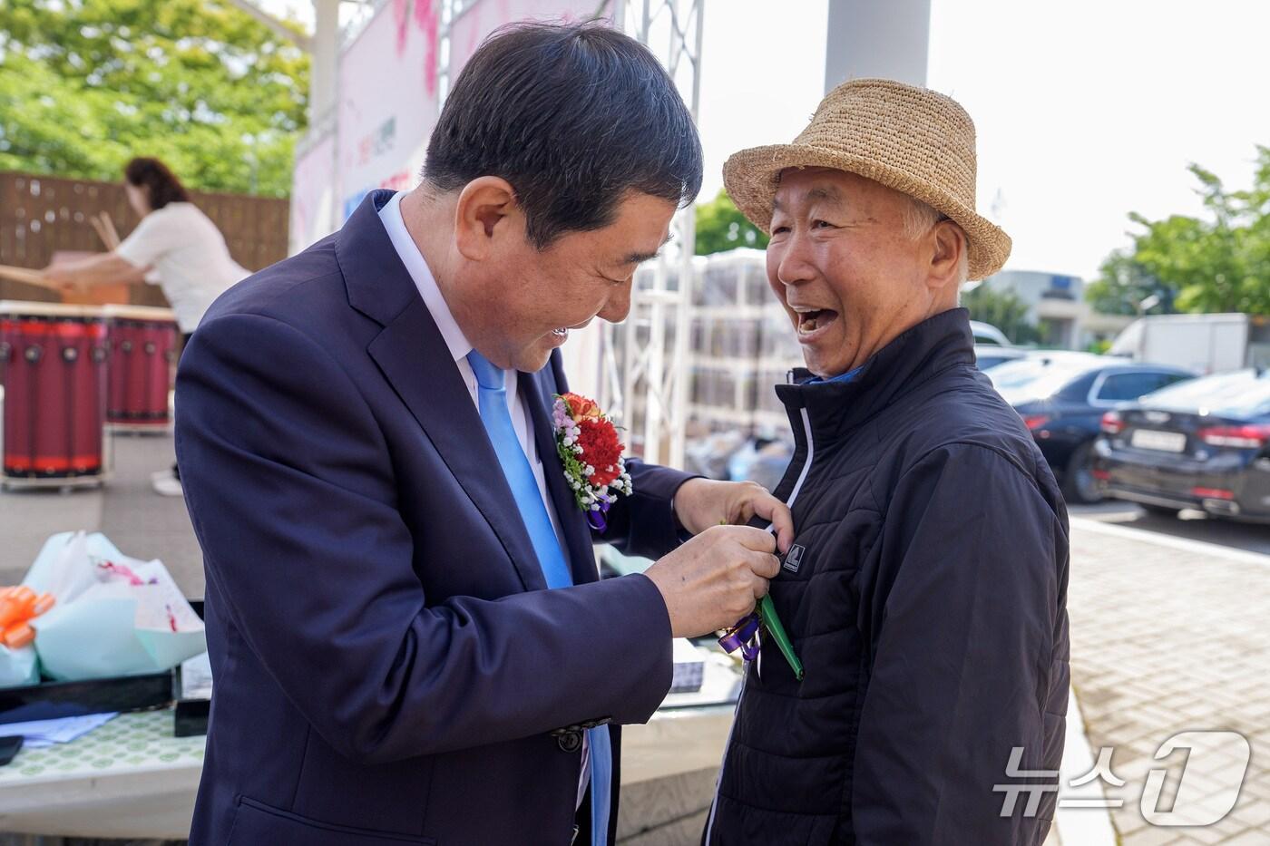 충북 증평군 도안면 이장협의회가 주관한 도안면 어버이날 행사에 참석한 이재영 증평군수가 어르신에게 카네이션을 달아주고 있다.(증평군 제공)/뉴스1