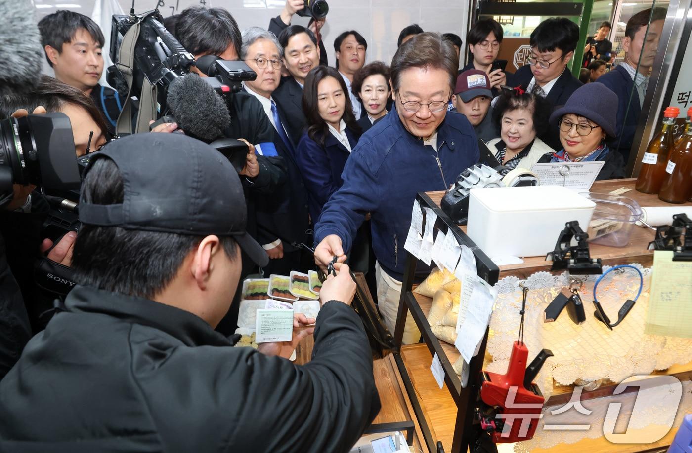 지난 5월 2일 이재명 당시 더불어민주당 대통령 후보가 강원 인제군 북면 원통시장에 위치한 떡집을 찾아 지역화폐로 콩가루를 구입하고 있다. (공동취재)  ⓒ News1 이재명 기자