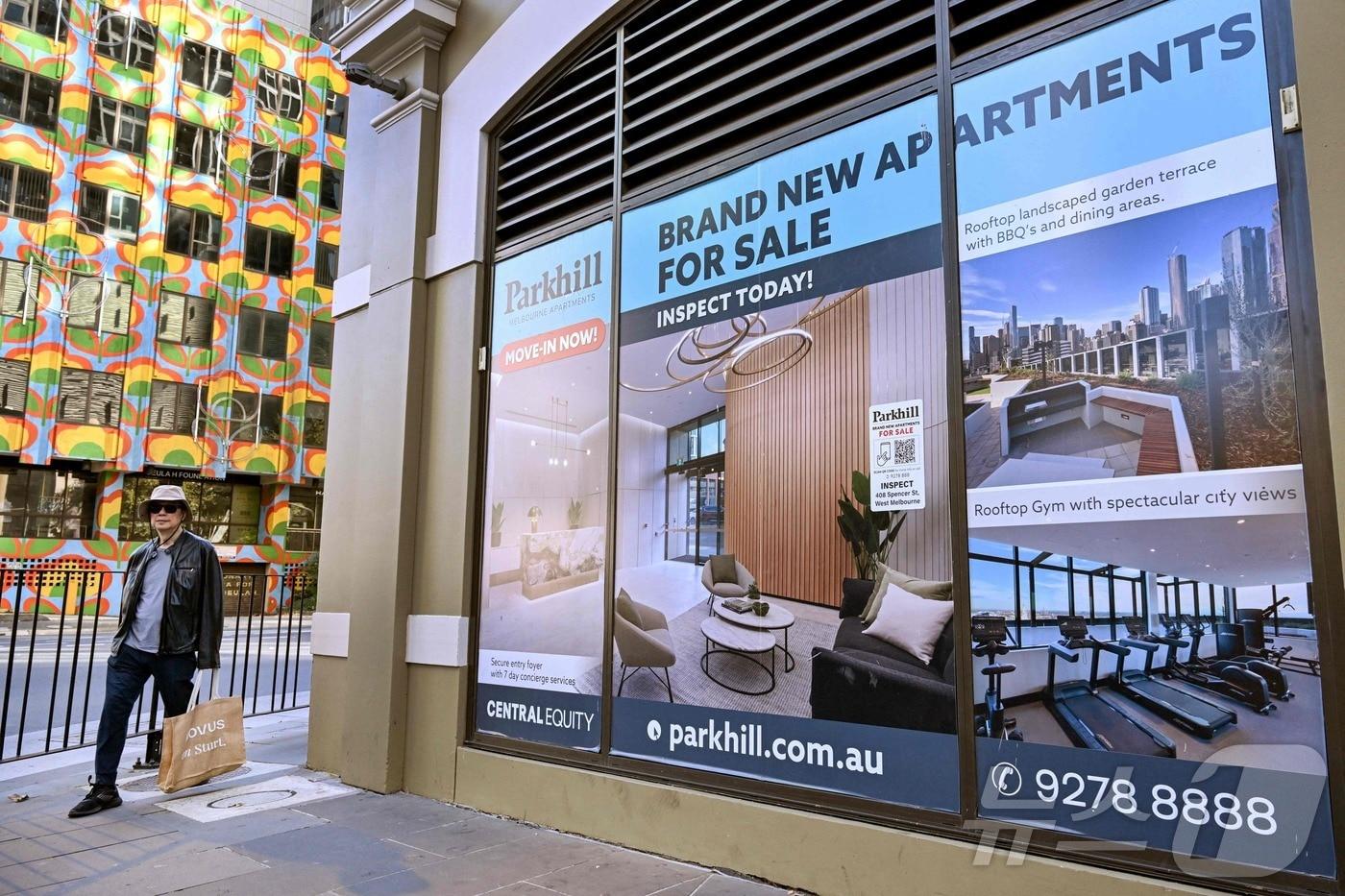 본문 이미지 - 한 남성이 호주 멜버른의 새 아파트 광고판 앞을 지나가고 있다. 2025.5.20 ⓒ AFP=뉴스1