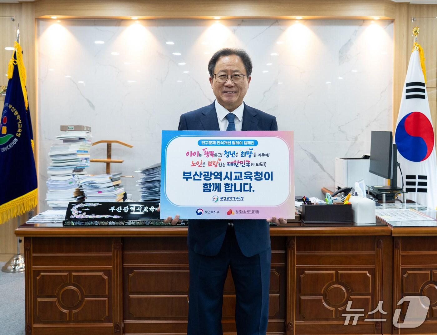 본문 이미지 - 김석준 부산시교육감이 피켓을 들고 '인구문제 인식개선 릴레이 캠페인'에 동참하고 있다.(부산시교육청 제공. 재판매 및 DB 금지)