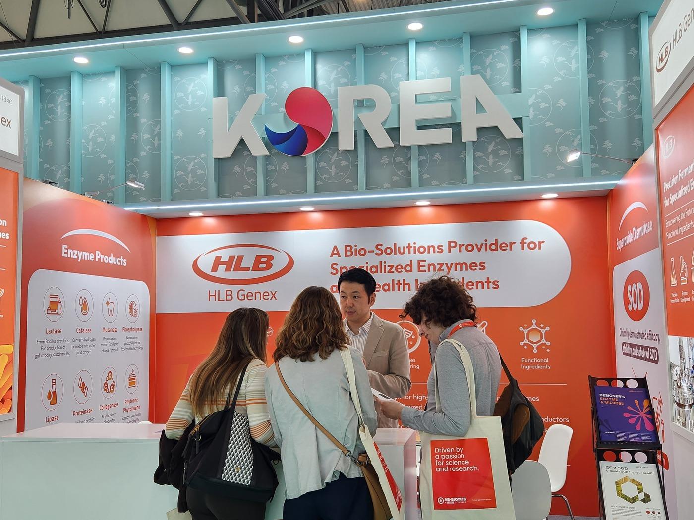 본문 이미지 - 스페인 바르셀로나에서 열리고 있는 '비타푸드 유럽 2025'에 마련된 HLB제넥스의 부스에 방문객들이 설명을 듣고 있다. (HLB제넥스 제공)
