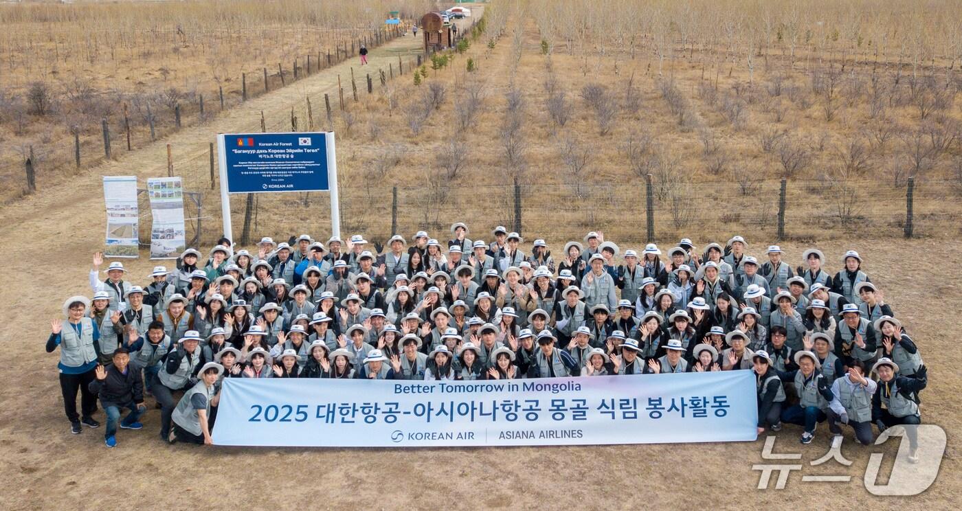 본문 이미지 - 대한항공·아시아나항공 직원들이 19일 몽골 울란바타르시 바가노르구에 위치한 ‘대한항공 숲’에서 식림 활동을 진행한 뒤 기념사진을 촬영한 모습(대한항공 제공). 2025.05.19.
