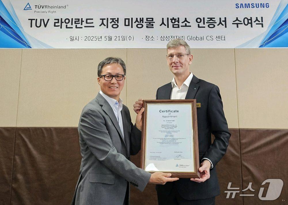본문 이미지 - 삼성전자 김학상 글로벌CS센터장(왼쪽)과 TUV 라인란드 한국지사 프랭크 마이클 주트너 대표가 인증서를 들고 기념 촬영을 하고 있다(삼성전자 제공). ⓒ 뉴스1