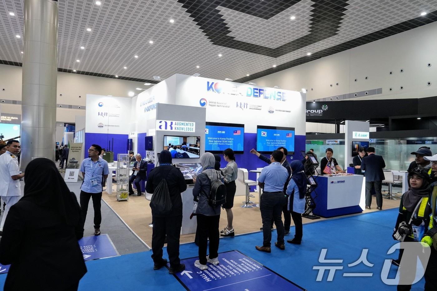 말레이시아 랑카위 방산전시회 &#39;LIMA 2025&#39;의 이튿날인 지난 21일&#40;현지시간&#41; 전시회 참가자들이 전시회장에 마련된 한국관 앞에서 참가업체 관계자의 설명을 듣고 있다. &#40;한국방위산업진흥회 제공. 재판매 및 DB 금지&#41; 2025.5.22/뉴스1