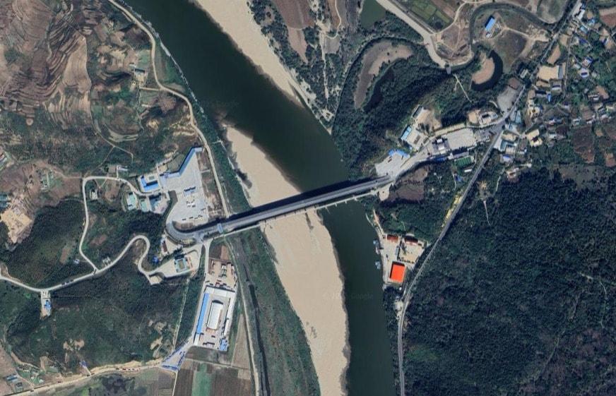 본문 이미지 - 북한 함경북도 나선(나진·선봉)특별시의 원정리와 중국 지린성 훈춘시를 잇는 취안허(圈河) 검문소 전경. (구글 어스 갈무리)