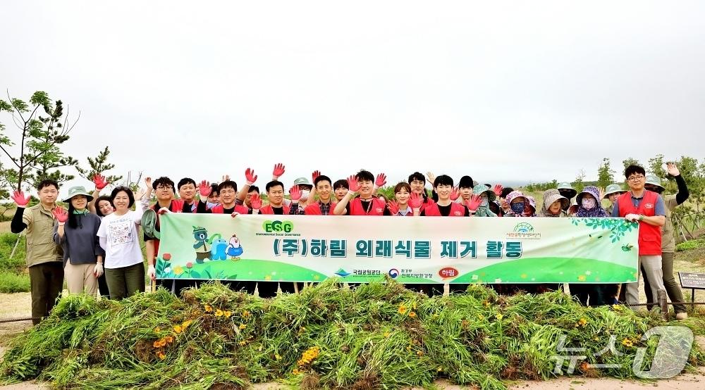 본문 이미지 - 하림 임직원들이 새만금환경생태단지에서 외래식물 제거 봉사활동을 마친 후 기념사진을 촬영하고 있다.&#40;하림 제공. 재판매 및 DB금지&#41;
