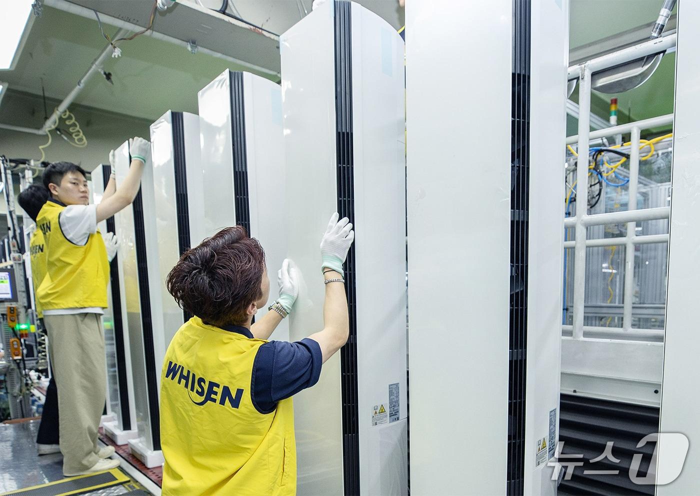 본문 이미지 - LG전자 직원들이 경남 창원의 LG전자 에어컨 생산라인에서 스탠드 에어컨을 생산하고 있는 모습. (사진제공 = LG전자) 