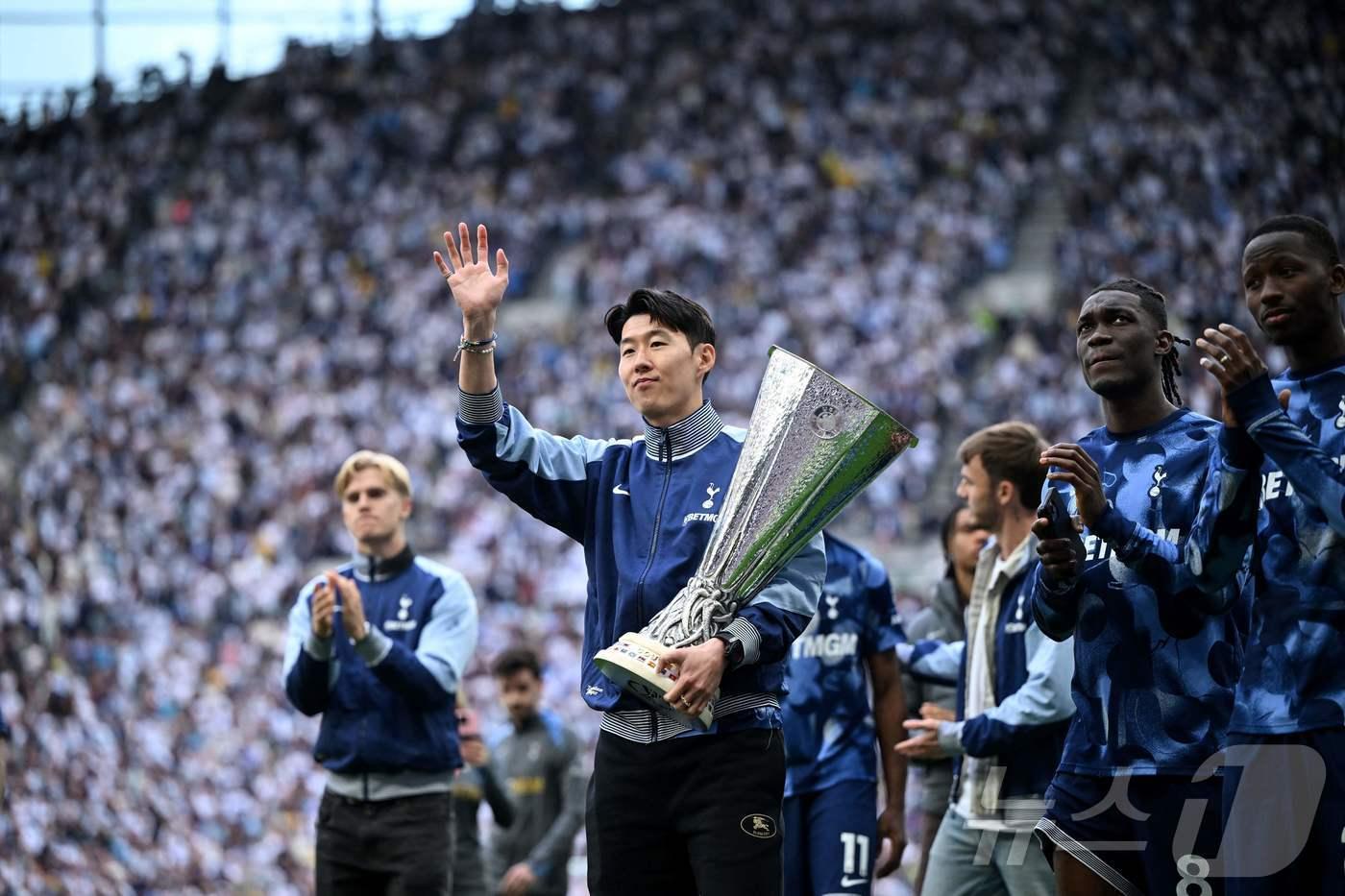 손흥민이 26일&#40;한국시간&#41; 열린 EPL 시즌 최종전이 끝난 뒤 유로파리그 우승 트로피를 들고 팬들에게 인사하고 있다. ⓒ AFP=뉴스1