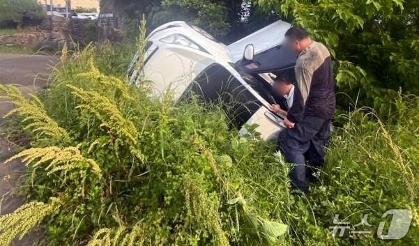 본문 이미지 - 지난 25일 오전 7시14분쯤 제주시 도련1동에서 승용차가 고랑에 빠져 탑승자가 차안에 갇히는 사고가 발생했다.(제주도소방안전본부 제공. 재판매 및 DB 금지)