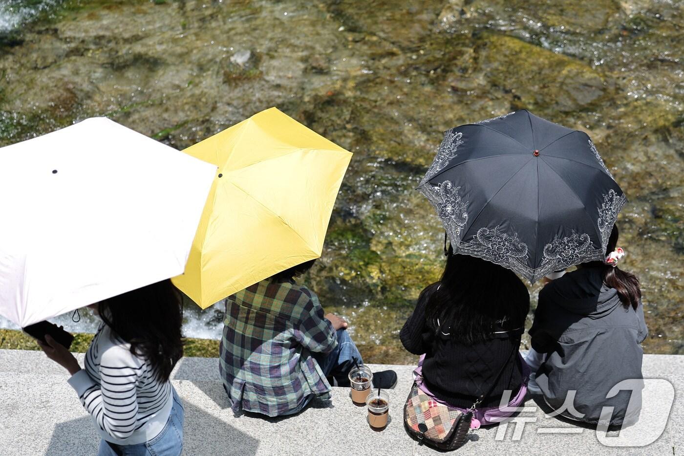 26일 오후 서울 청계광장에서 겉옷을 벗거나 양산을 쓴 시민들이 올해 마지막 봄을 즐기고 있다. 2025.5.26/뉴스1 ⓒ News1 신웅수 기자