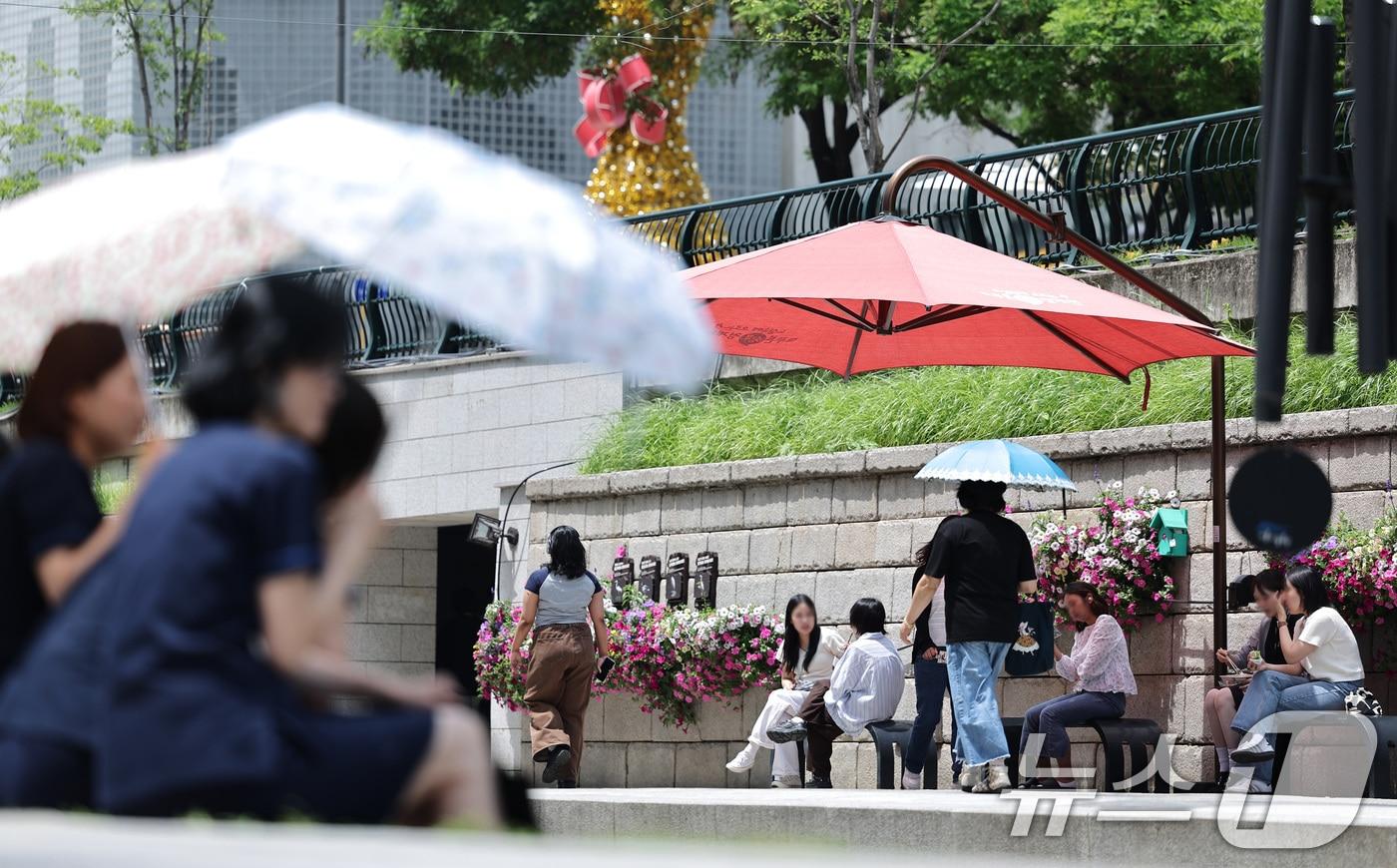 본문 이미지 - 26일 오후 서울 청계광장에서 양산을 쓴 시민들이 올해 마지막 봄을 즐기고 있다. 기상청은 내일과 모레 동쪽 지방을 중심으로 요란한 소나기가 지나가고 주 후반에는 30도 안팎의 더위가 나타날 것으로 예보했다. 2025.5.26/뉴스1 ⓒ News1 신웅수 기자