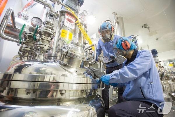 본문 이미지 - 에스티팜 연구원들이 바이오리액터를 점검하고 있다.&#40;에스티팜 제공&#41;/뉴스1