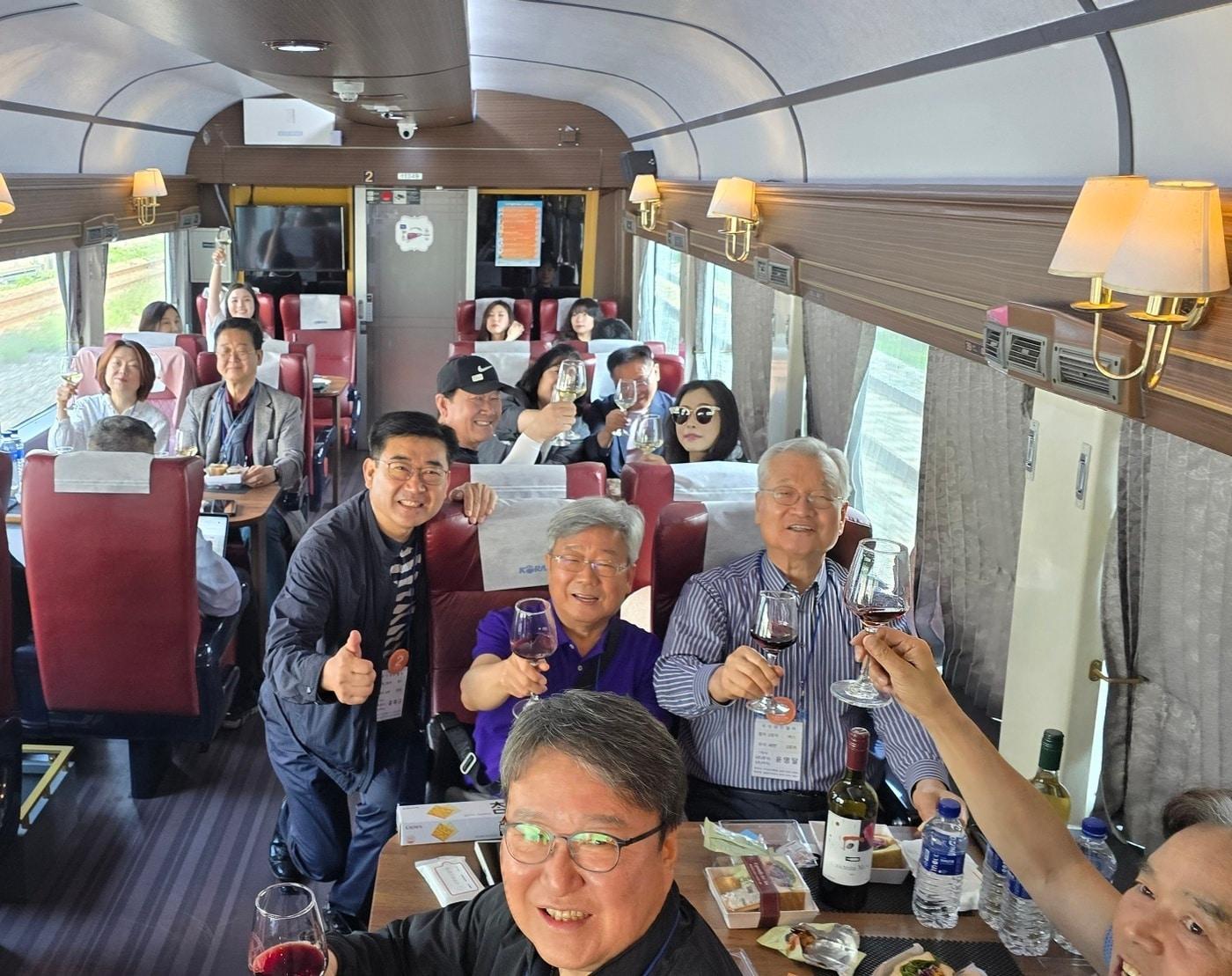 본문 이미지 - 윤영달  크라운해태 회장&#40;우측 2번째 줄&#41;이 영동국악와인열차에서 국악계 리더들과 팸투어를 진행하고 있다.&#40;크라운해태제과 제공&#41;