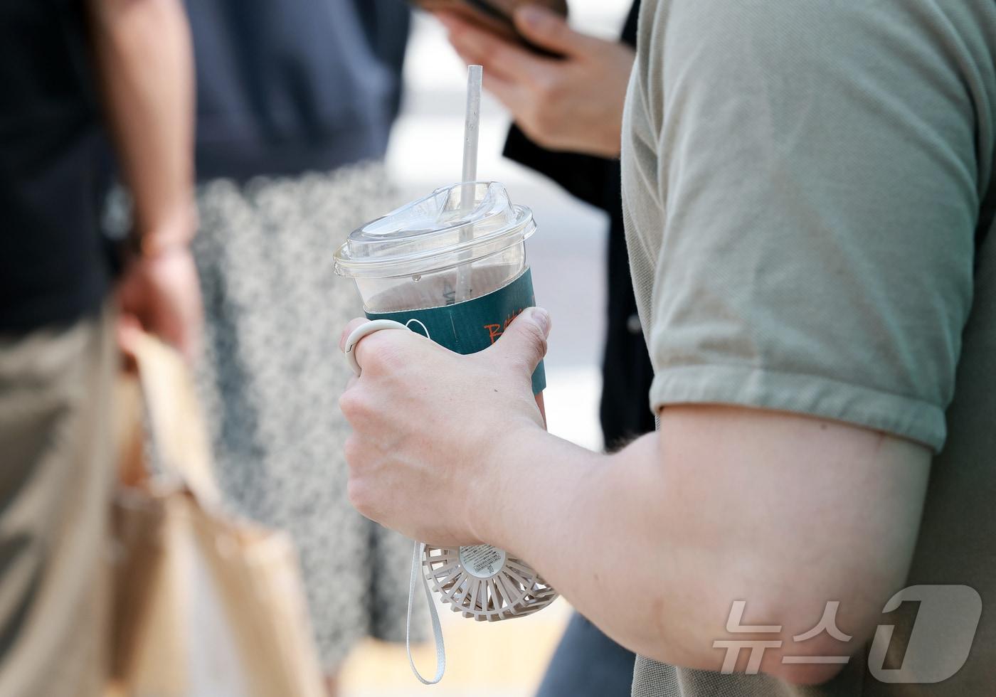 낮 최고 기온이 28도까지 오르며 초여름 날씨를 보인 27일 서울 영등포구 여의나루역 인근에서 한 시민이 시원한 음료와 미니 선풍기를 손에 들고 있다. 2025.5.27/뉴스1 ⓒ News1 김진환 기자