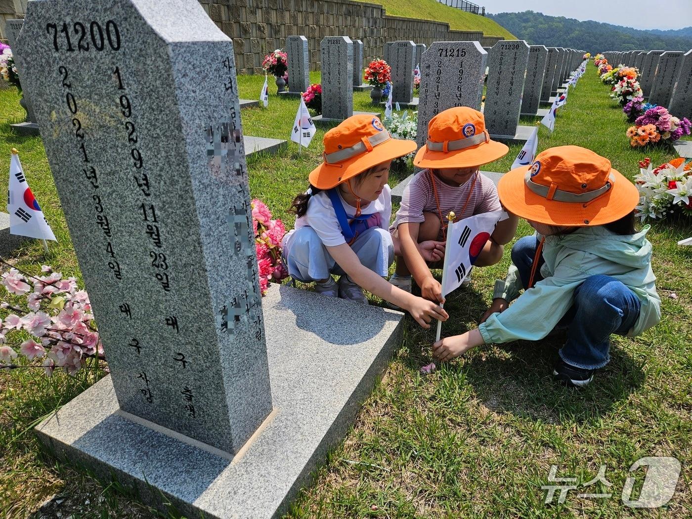 본문 이미지 - 국립대전현충원 묘역애 태극기를 꽂고 는 한국119청소년단 어린이들(대전소방본부 제공) /뉴스1
