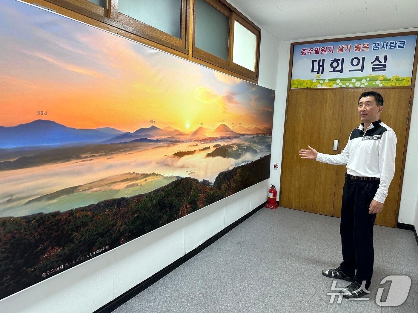 본문 이미지 -  27일 홍대희 충북 충주시 용산동장이 이광주 작가의 '충주의 아침' 사진 작품을 설명하고 있다.(재판매 및 DB금지)/뉴스1