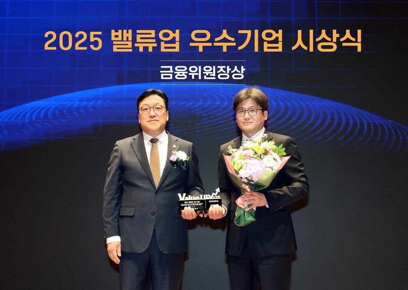 27일 오후 서울 여의도 한국거래소에서 열린 '2025 밸류업 우수기업 시상식'에서 장석훈 삼양식품 경영지원본부장(오른쪽)과 김병환 금융위원회 위원장(왼쪽)이 기념 촬영을 하고 있다. (삼양식품 제공)
