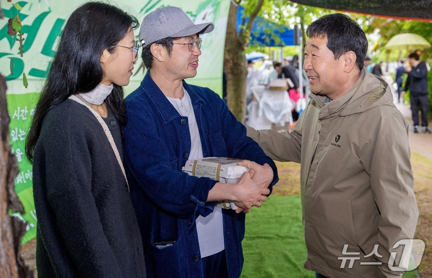 충북 증평 송산초등학교 터에 조성한 청보리밭에서 셀프 웨딩사진을 촬영하고, 결혼 후 증평에 보금자리를 마련한 신혼부부에게 이재영 증평군수가 따뜻한 환영 인사를 전하고 있다.(증평군 제공, 재판매 및 DB금지)/뉴스1