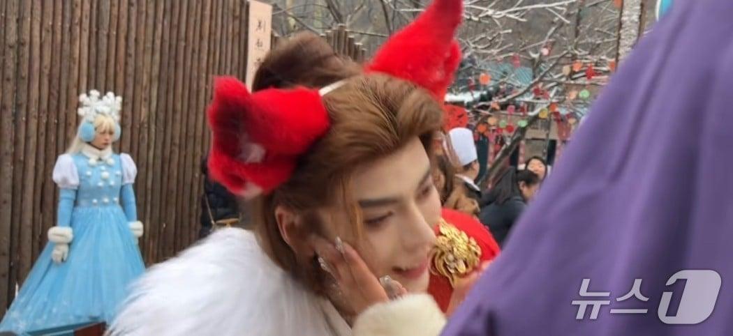 본문 이미지 - 지난해 1월 허난성 윈타이산 빙설제 홍보를 위해 채용된 남성 직원이 관광객들과 사진을 찍어주는 장면. (샤오훙슈 갈무리)