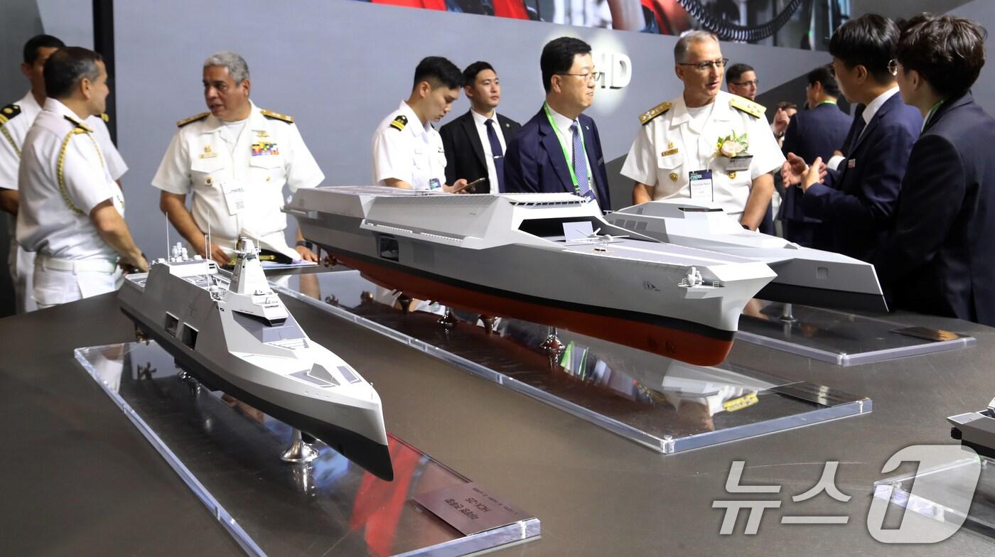 28일 부산 해운대구 벡스코 제1전시장에서 열린 '2025 국제해양방위산업전(MADEX)'에서 참가자들이 HD현대중공업 부스를 찾아 미래형 무인전력모함 등을 살펴보고 있다.  2025.5.28/뉴스1 ⓒ News1 윤일지 기자