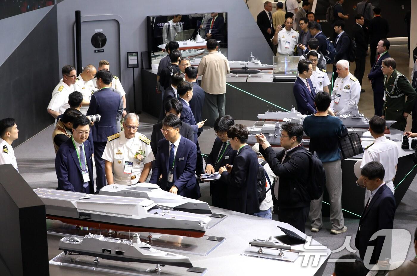 28일 부산 해운대구 벡스코 제1전시장에서 열린 '2025 국제해양방위산업전(MADEX)'에서 참가자들이 HD현대중공업 부스를 찾아 미래형 무인전력모함 등을 살펴보고 있다. 2025.5.28/뉴스1 ⓒ News1 윤일지 기자