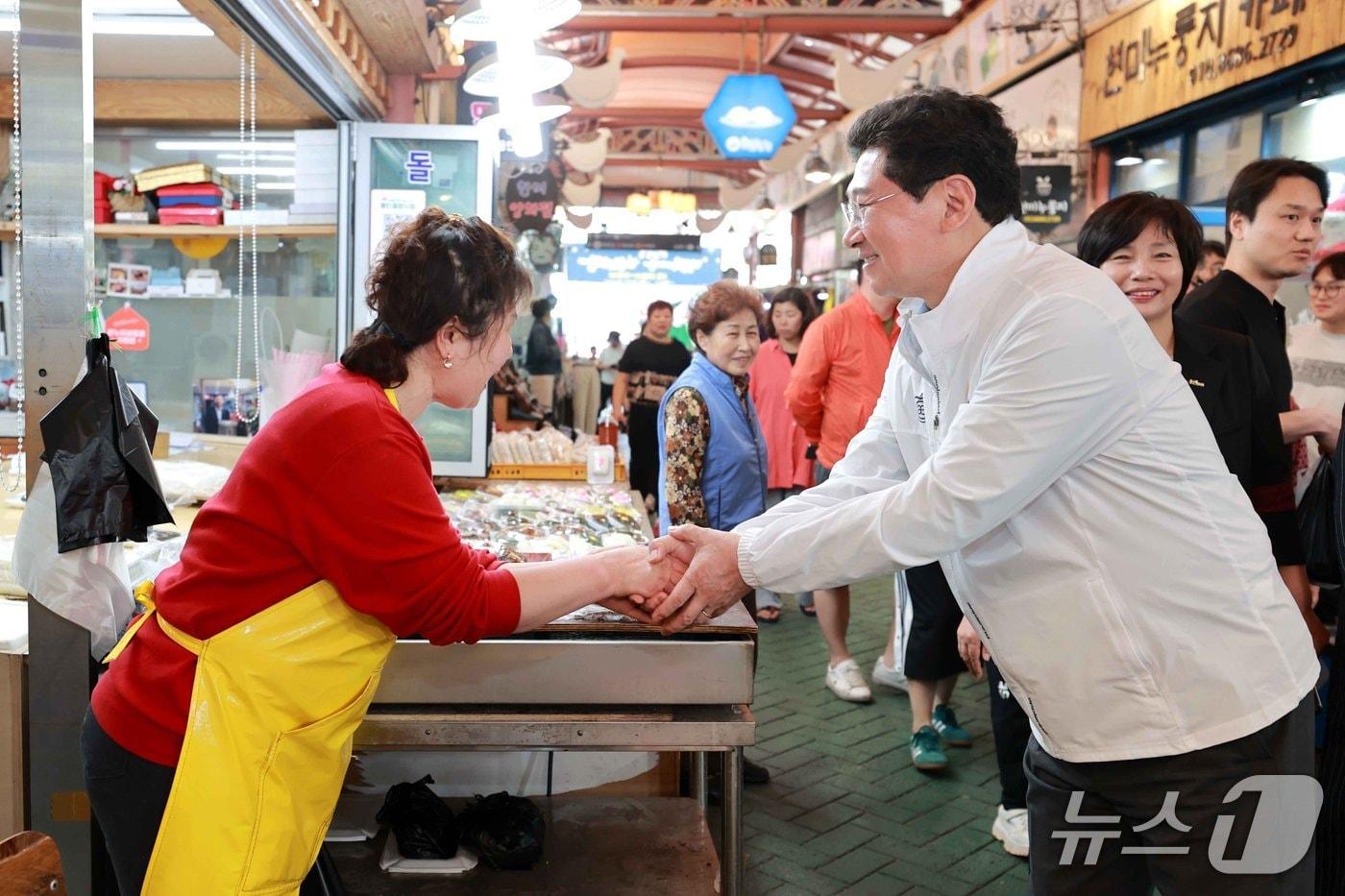 지난해 4월 용인중앙시장에서 열린 ‘왁자지껄 봄 축제’에서 이상일 시장이 상인과 인사를 하고 있는 모습.(용인시 제공)