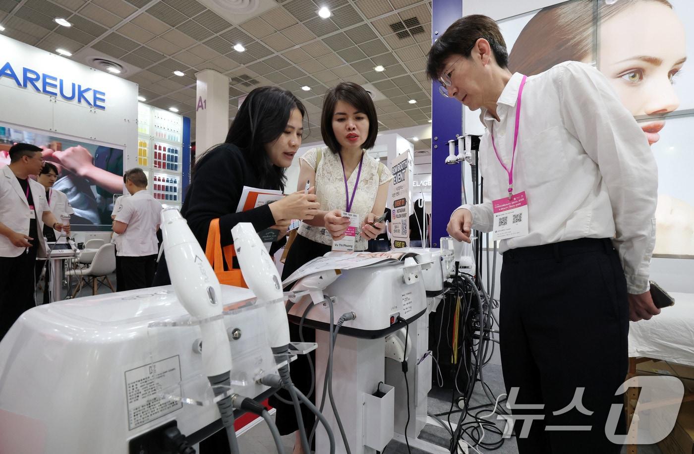 28일 서울 강남구 코엑스에서 열린 ‘2025 서울국제화장품미용산업박람회, 국제건강산업박람회&#40;코스모뷰티서울, 헬스&뷰티위크&#41;’를 찾은 외국인 관람객이 미용기기를 살펴보고 있다.2025.5.28/뉴스1 ⓒ News1 박세연 기자