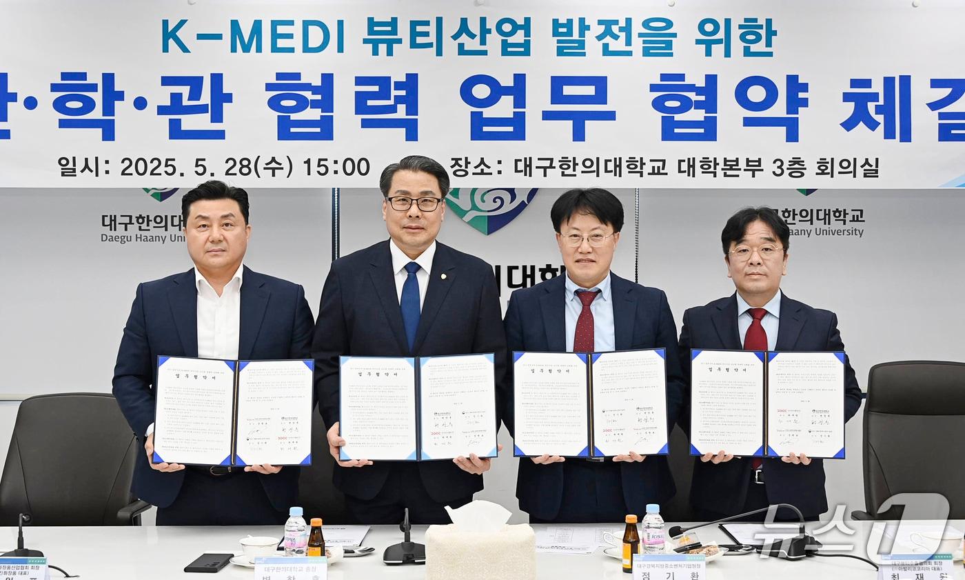 장원표 경북도화장품산업협회장(왼쪽부터)과 변창훈 대구한의대 총장, 정기환 대구·경북지방중소벤처기업청장, 최재원 대구뷰티수출협의회장이 K-MEDI 뷰티산업 발전을 위한 산·학·관 협력 업무협약을 체결한 뒤 협약서를 펼쳐 보이고 있다.(대구경북중기청 제공. 재판매 및 DB 금지)