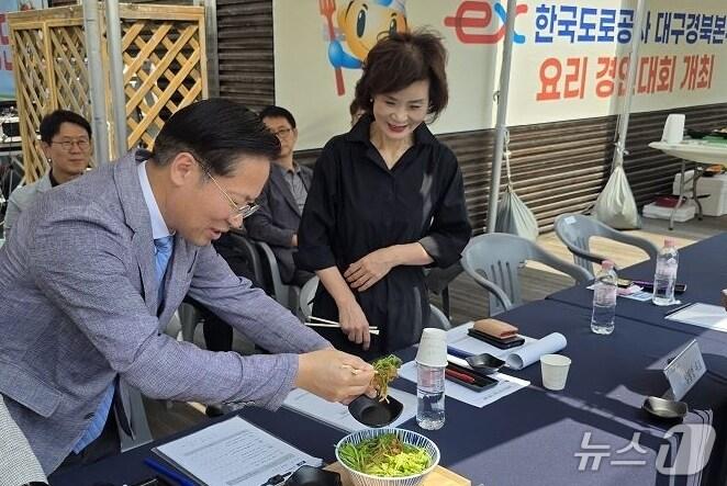 본문 이미지 - 유호식 도로공사 대구경북본부장이 지난 27일 논공(대구방향)휴게소에서 열린 '대구경북제일맛! 숨은 맛 고수 찾기' 요리경연대회에서 참가자가 제출한 요리를 시식하고 있다. (도로공사 대구경북본부 제공. 재판매 및 DB금지) 2025.5.28/뉴스1