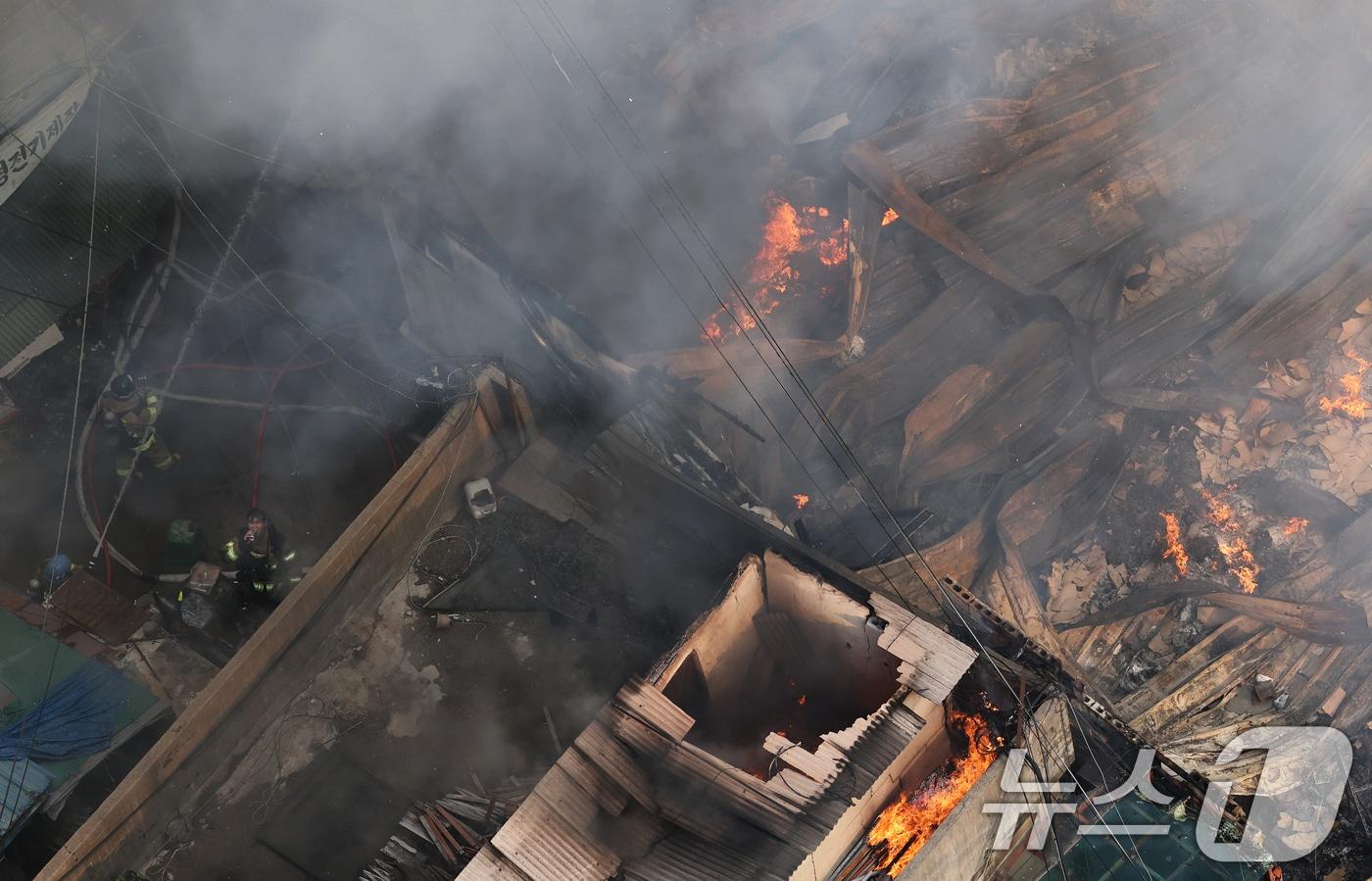 28일 오후 서울 중구 을지로 세운상가 인근 재개발 예정지구에서 화재가 발생한 가운데 한 소방대원이 시커먼 화마 속에서 잠시 목을 축이고 있다. 2025.5.28/뉴스1 ⓒ News1 오대일 기자