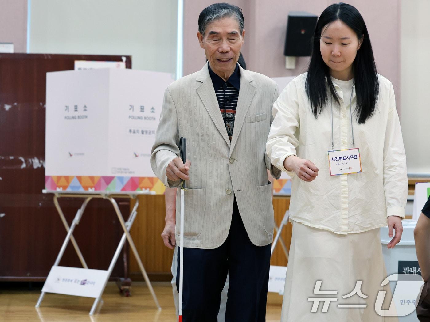 본문 이미지 - 제21대 대통령 선거 사전 투표 첫날인 29일 오전 서울 종로구 무악동주민센터에 마련된 사전투표소에서 시각장애인 유권자가 사전투표사무원의 도움을 받으며 투표를 하고 있다. 2025.5.29/뉴스1 ⓒ News1 황기선 기자