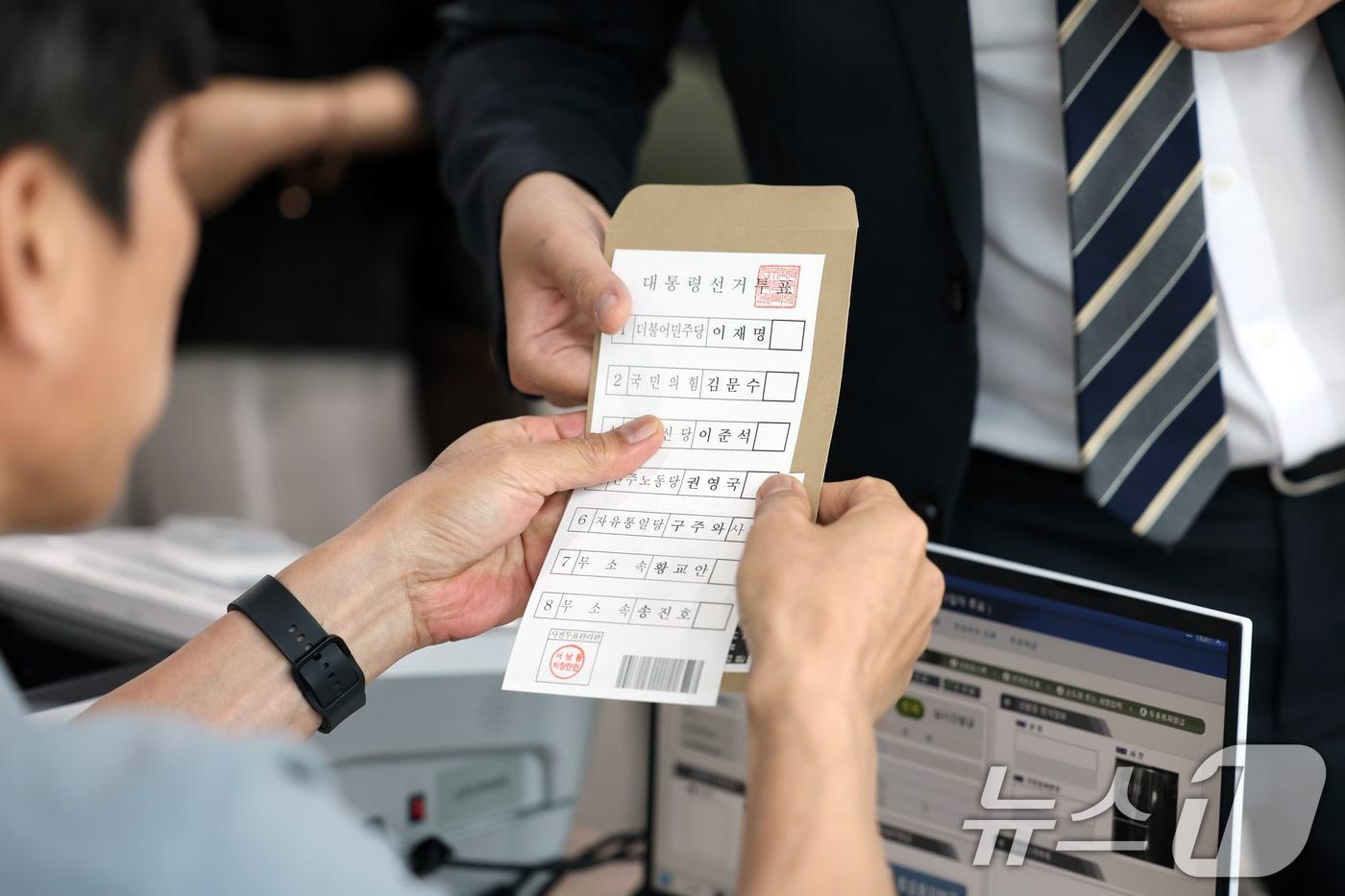 제21대 대통령 사전투표 첫날인 29일 광주 동구 서남동 사전투표소에서 선거사무원이 유권자에게 투표 용지를 건네고 있다. 2025.5.29/뉴스1 ⓒ News1 이승현 기자