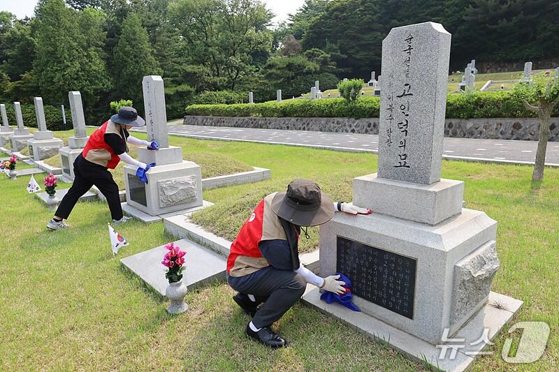 본문 이미지 - 롯데이노베이트 임직원들이 현충원 묘역을 단장하고 있다.(롯데이노베이트 제공)