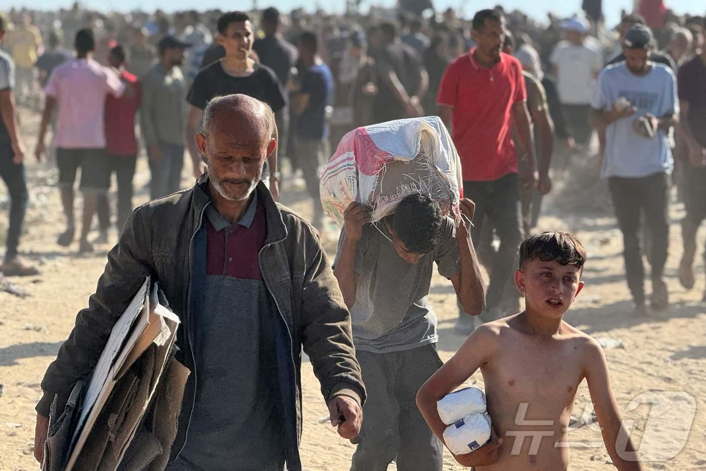 가자지구 남쪽 라파에 있는 구호품 배급소에서 식량 꾸러미를 받아가고 있는 팔레스타인인들. 2025.05.28. ⓒ AFP=뉴스1 ⓒ News1 권영미 기자