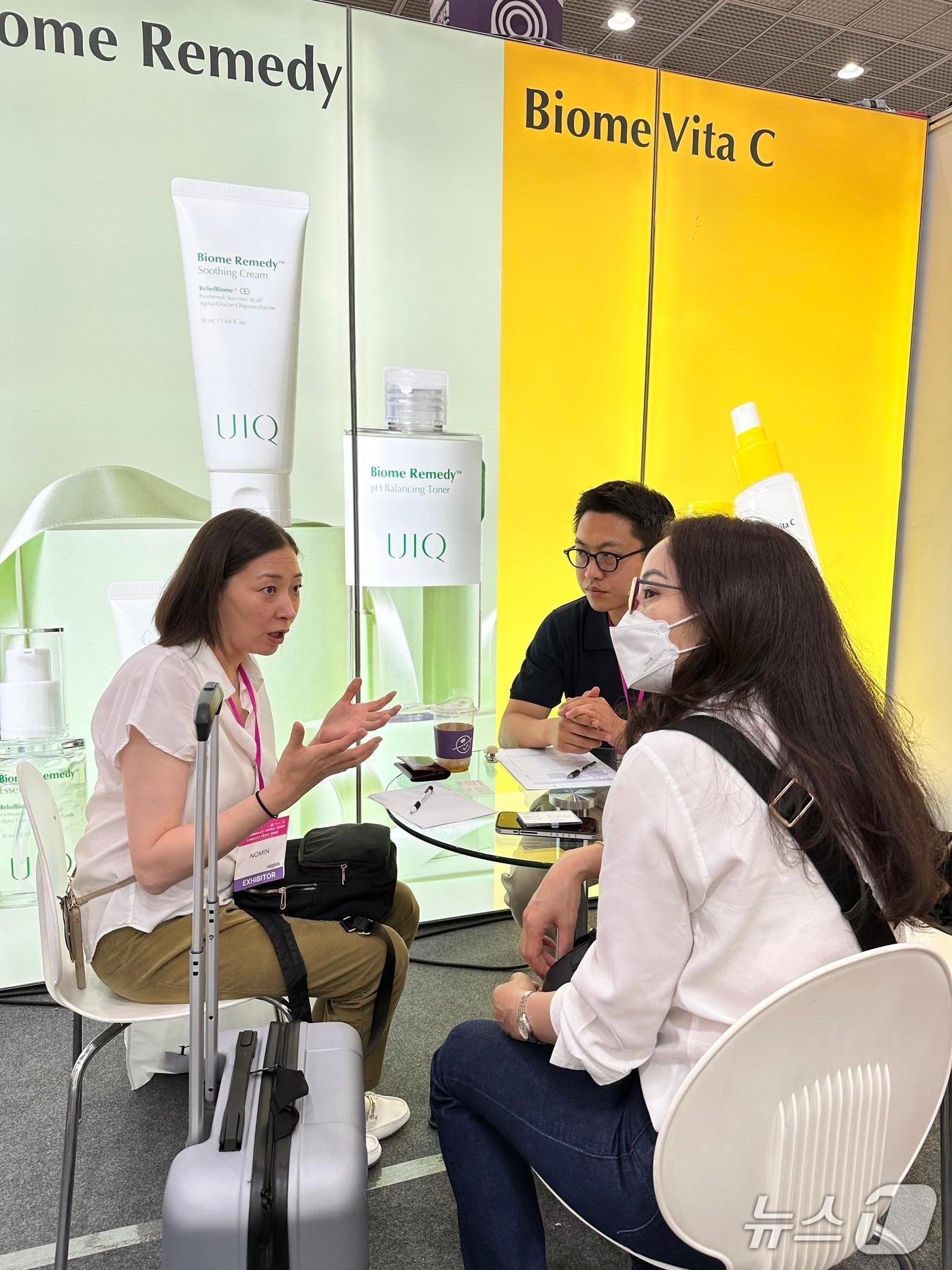 본문 이미지 - 지놈앤컴퍼니 유이크 관계자가 2025 코스모뷰티에 참가한 바이어 등에게 브랜드 소개를 하고 있다.(지놈앤컴퍼니 제공)/뉴스1
