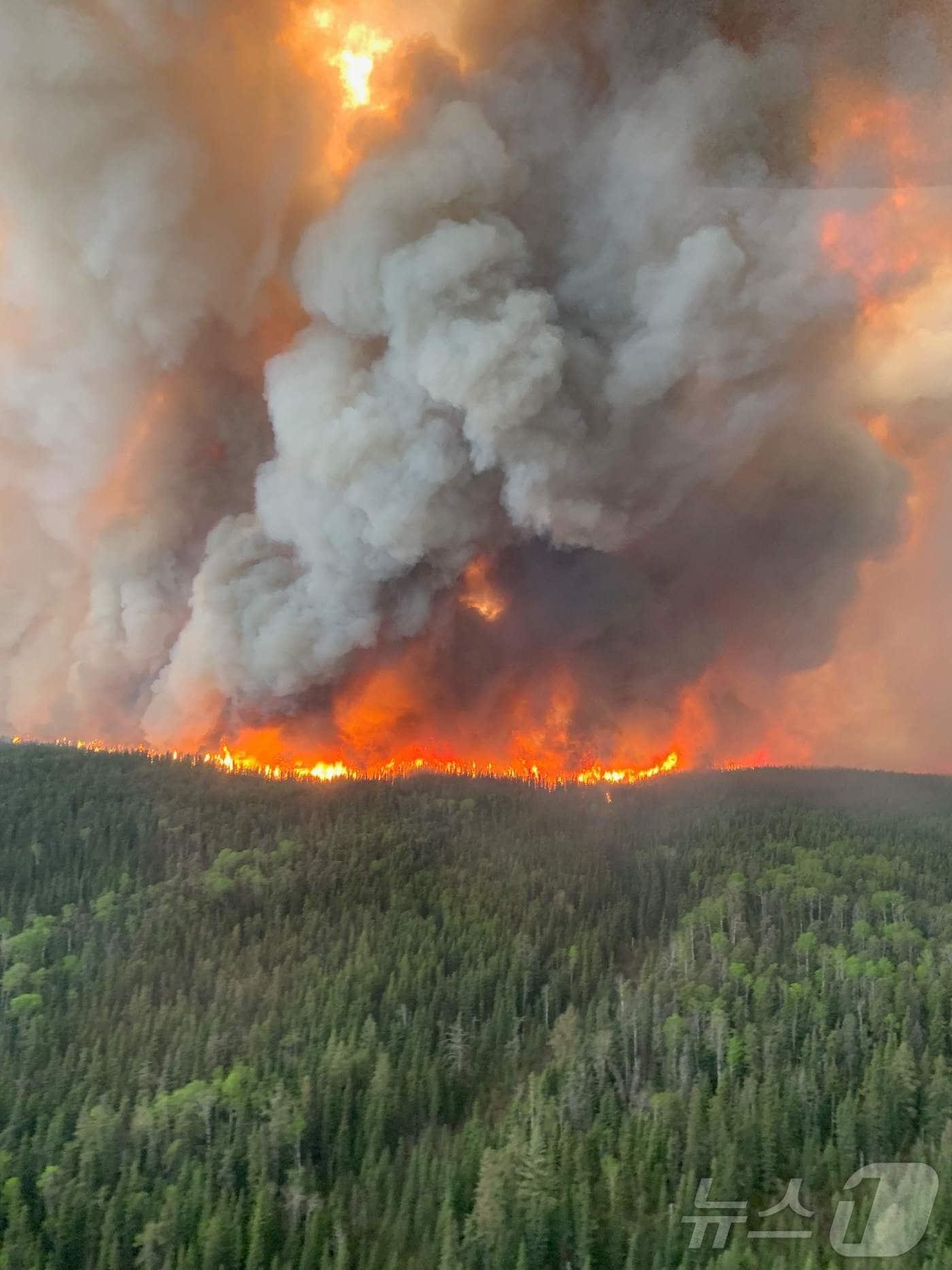 본문 이미지 - 27일(현지시간) 산불이 발생한 캐나다 매니토바에서 불길이 급속하게 확산되고 연기가 솟아 오르고 있다. 2025.05.30 ⓒ AFP=뉴스1 ⓒ News1 우동명 기자