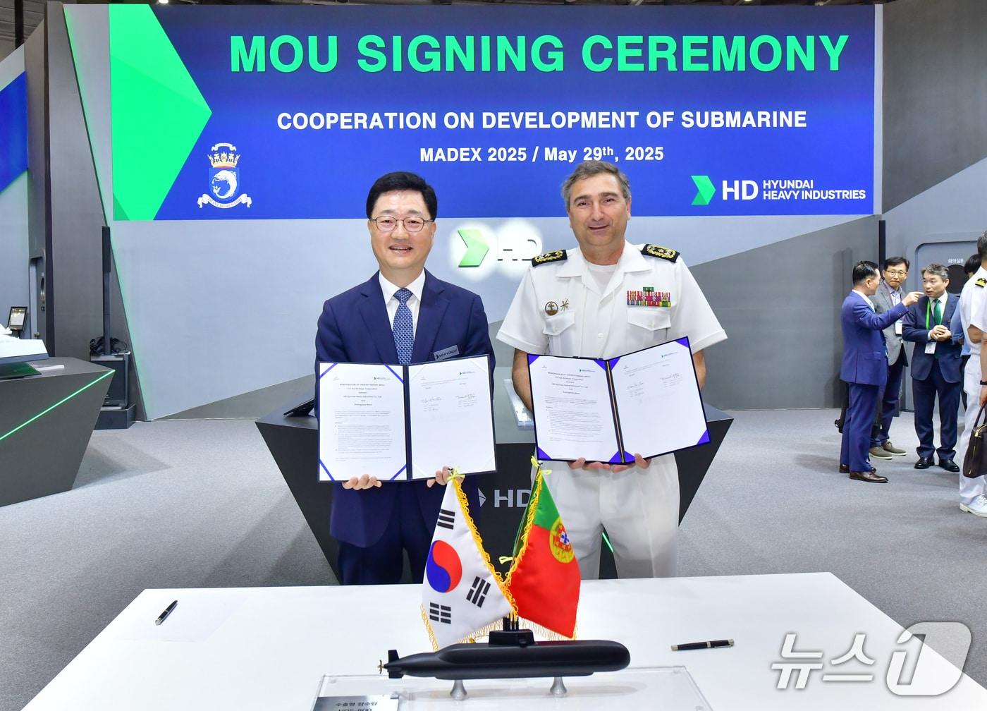 본문 이미지 - HD현대중공업이 부산 벡스코에서 열린 'MADEX 2025'에서 포르투갈 해군과 MOU를 체결하고 기념 촬영을 하고 있다(HD현대 제공)