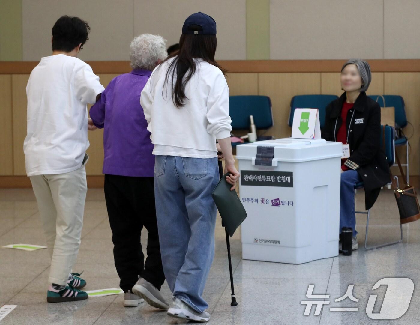 본문 이미지 - 제21대 대통령선거 사전투표 둘째 날인 30일 오전 부산 남구청 대강당에 마련된 사전투표소에서 거동이 어려운 지팡이를 짚은 어르신이 부축을 받으며 소중한 한 표를 행사하고 있다. 2025.5.30/뉴스1 ⓒ News1 윤일지 기자