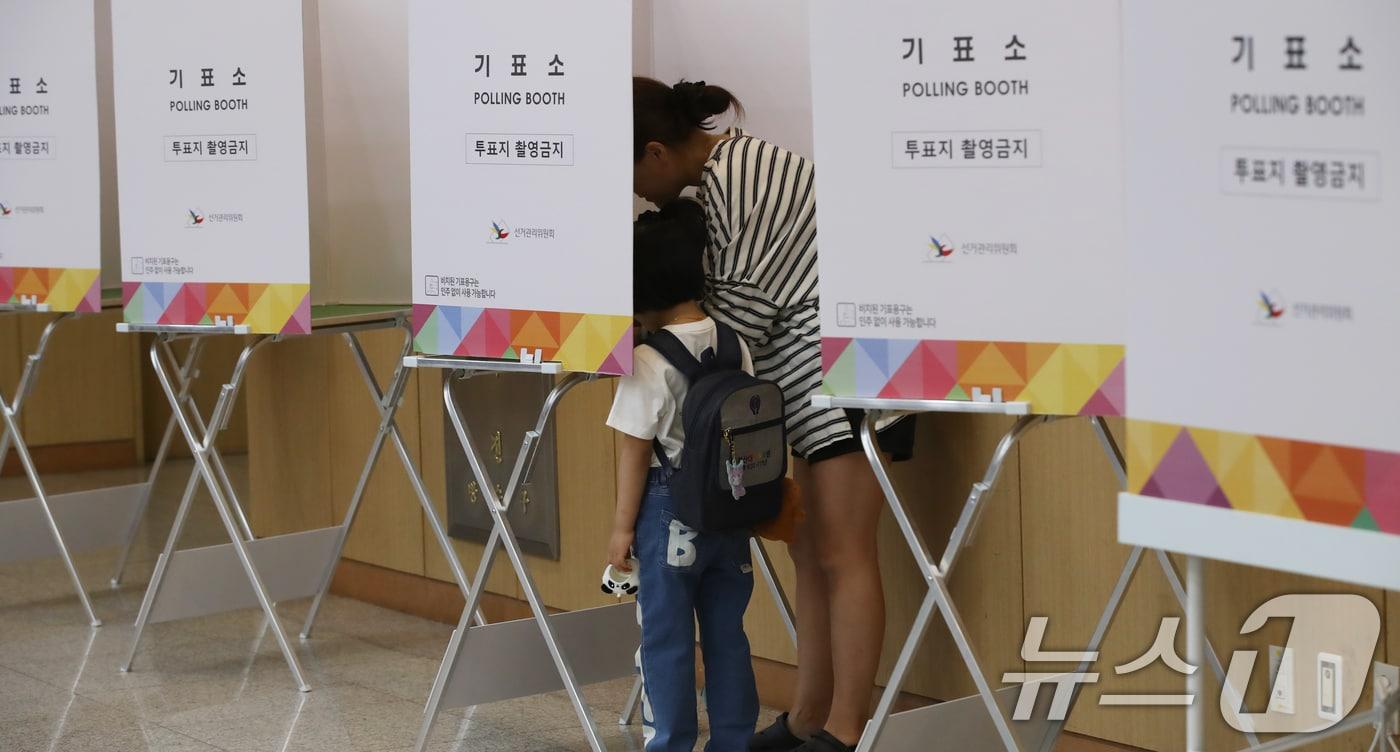 제21대 대통령선거 사전투표 둘째 날인 30일 오전 부산 남구청 대강당에 마련된 사전투표소에서 유권자가 아이와 함께 투표하고 있다. 2025.5.30/뉴스1 ⓒ News1 윤일지 기자