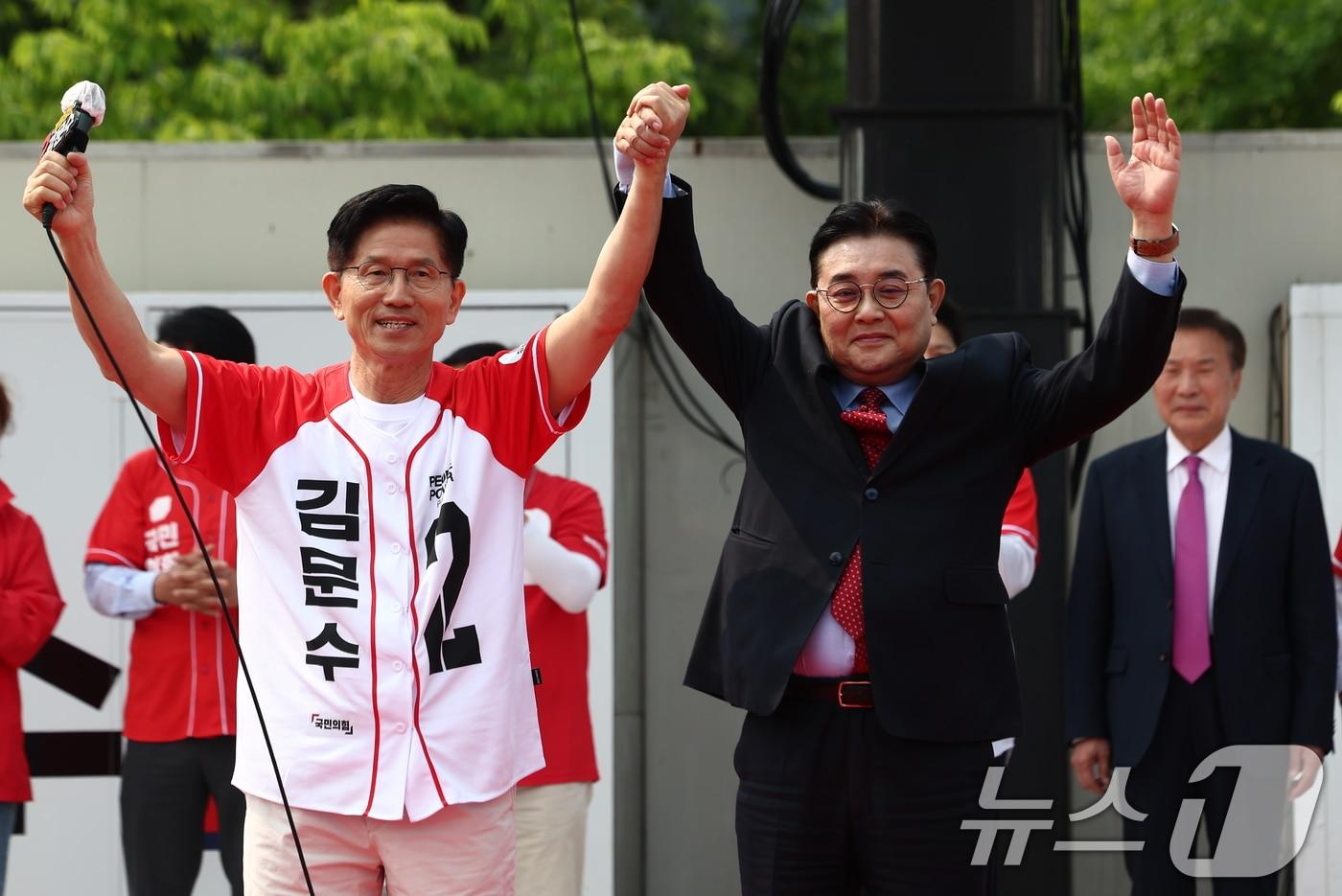 김문수 국민의힘 대통령 후보가 30일 경기 가평군 청평시계탑 광장에서 열린 유세에서 전병헌 새미래민주당 대표의 손을 맞잡고 있다. 오른쪽은 손학규 전 바른미래당 대표. 2025.5.30/뉴스1 ⓒ News1 김민지 기자