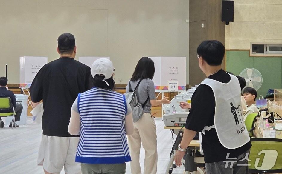 본문 이미지 - 지난 29일 세종시 보람동 복합커뮤니티센터 3층 체육강당에 마련된 투표소에서 유권자들이 투표용지를 받기 위해 기다리고 있다. ⓒ 뉴스1 장동열 기자