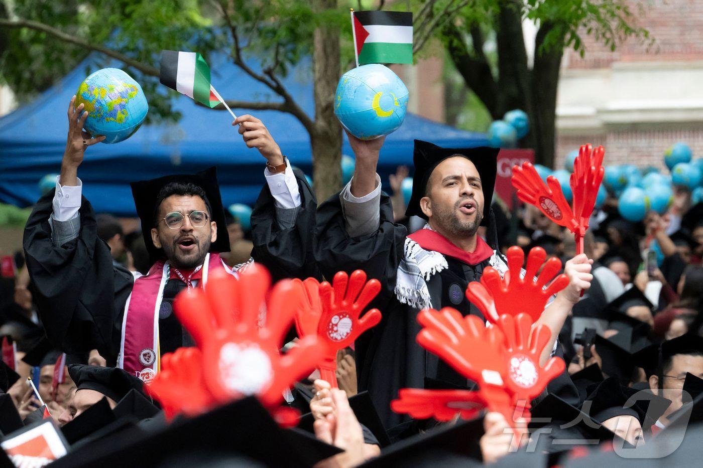 도널드 트럼프 미국 대통령의 압박에도 29일&#40;현지시간&#41; 하버드대 일부 졸업생들이 팔레스타인을 지지해 팔레스타인 깃발과 지구본을 흔들고 있다. 지구본은 팔레스타인과 가자 전쟁이 특정 지역의 문제가 아니라 전세계적인 정의와 자유의 문제로 봐야 한다는 메시지를 보이기 위한 것이다. 2025.05.29. ⓒ AFP=뉴스1 ⓒ News1 권영미 기자