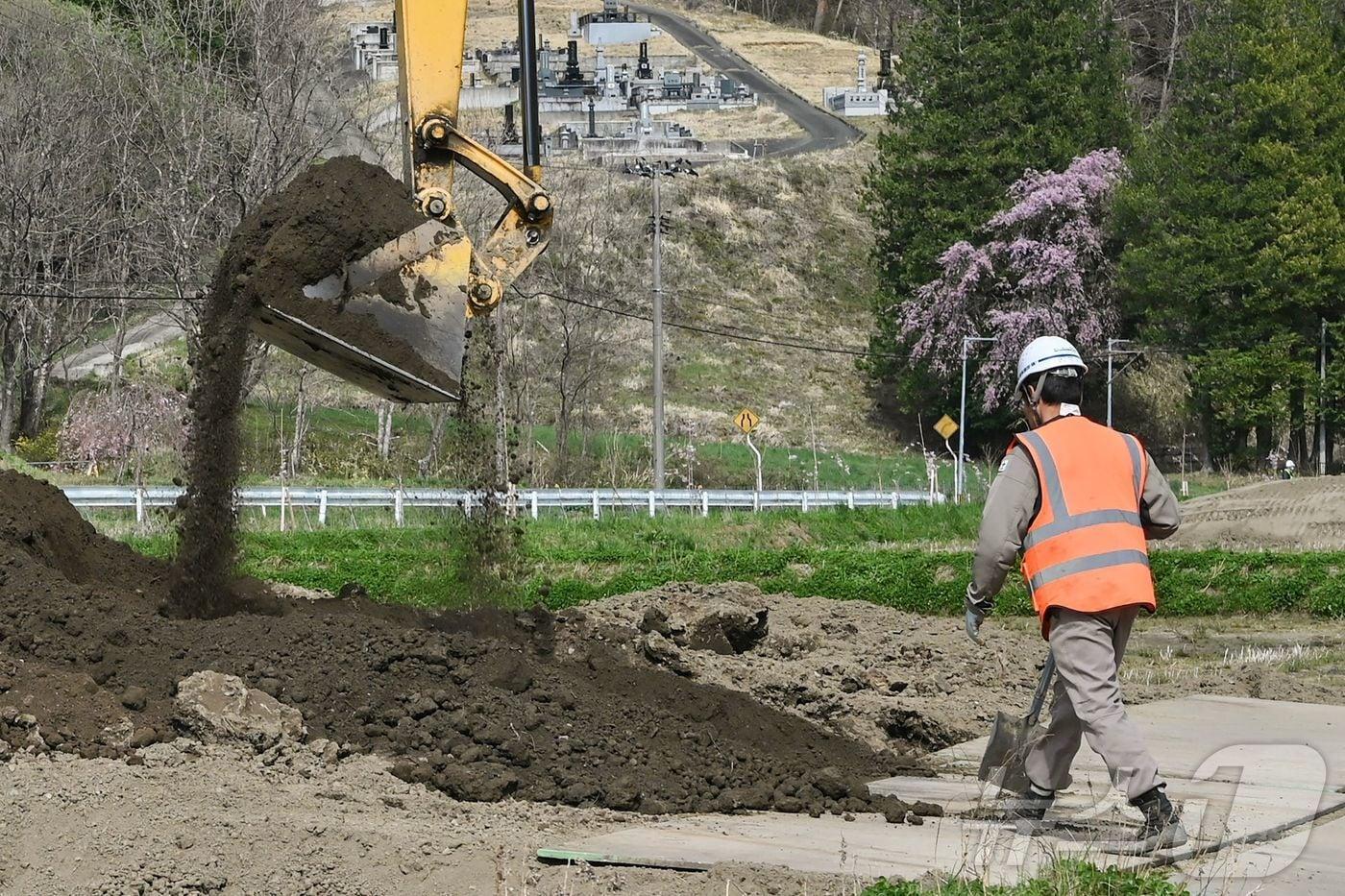 2011년 후쿠시마 원전사고로 피해를 입은 이이타테 마을에서 한 근로자가 2025년 4월22일 논에 새 흙을 덮고 있다. 최근 일본 정부는 후쿠시마 제염토&#40;오염물질 제거 후의 흙&#41;를 총리 관저에 반입하는 것을 추진 중이다. 2025.04.22. ⓒ AFP=뉴스1 ⓒ News1 권영미 기자